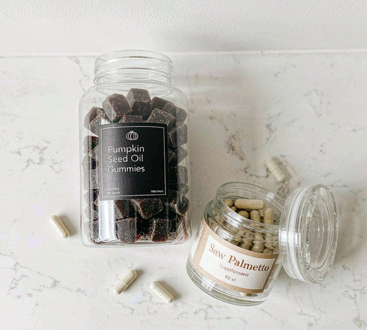 Flat lay of pumpkin seed oil gummies and saw palmetto capsules on bright white marble