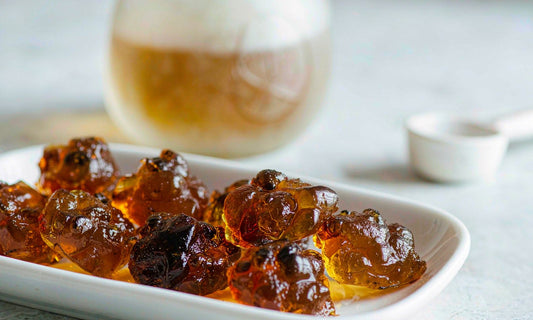 Macro close-up of amber pumpkin seed oil gummies in a shallow white ceramic dish