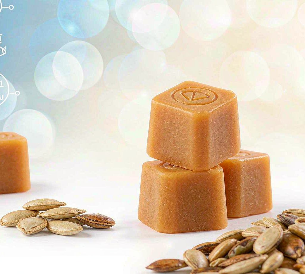 Pumpkin seed oil gummies beside scattered pumpkin seeds, bright airy studio